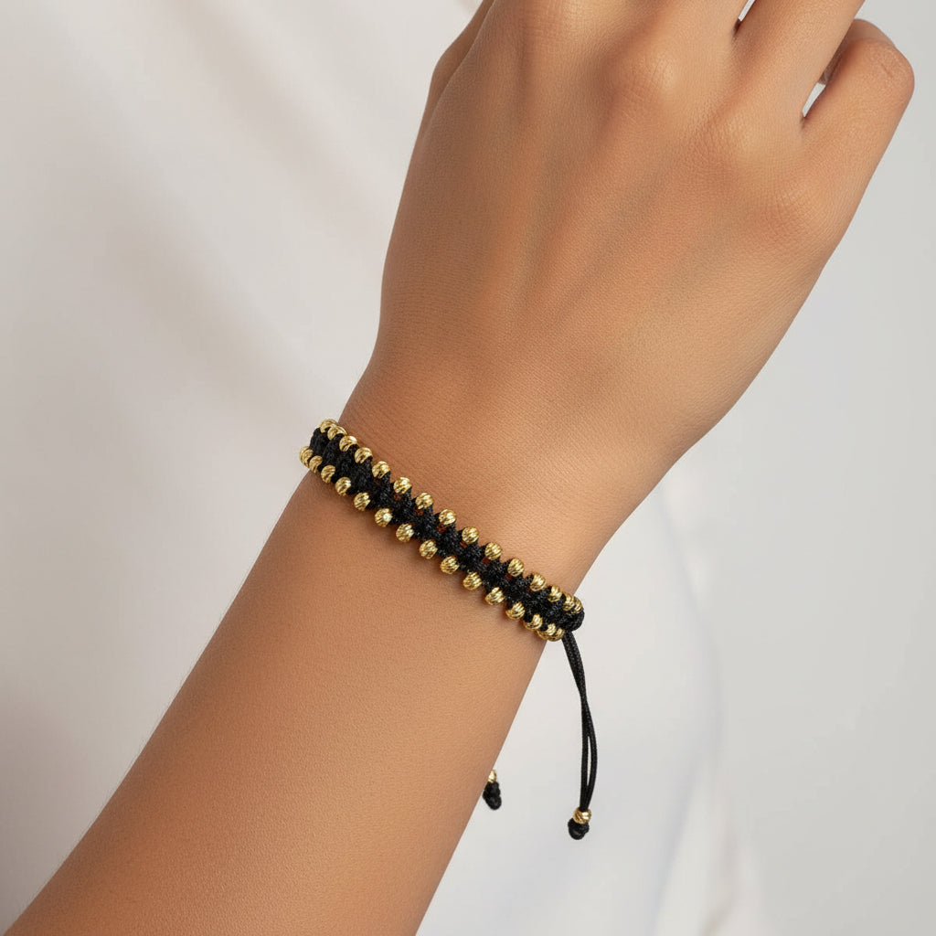Detalle de balines diamantados en pulsera oro 18K con hilo negro