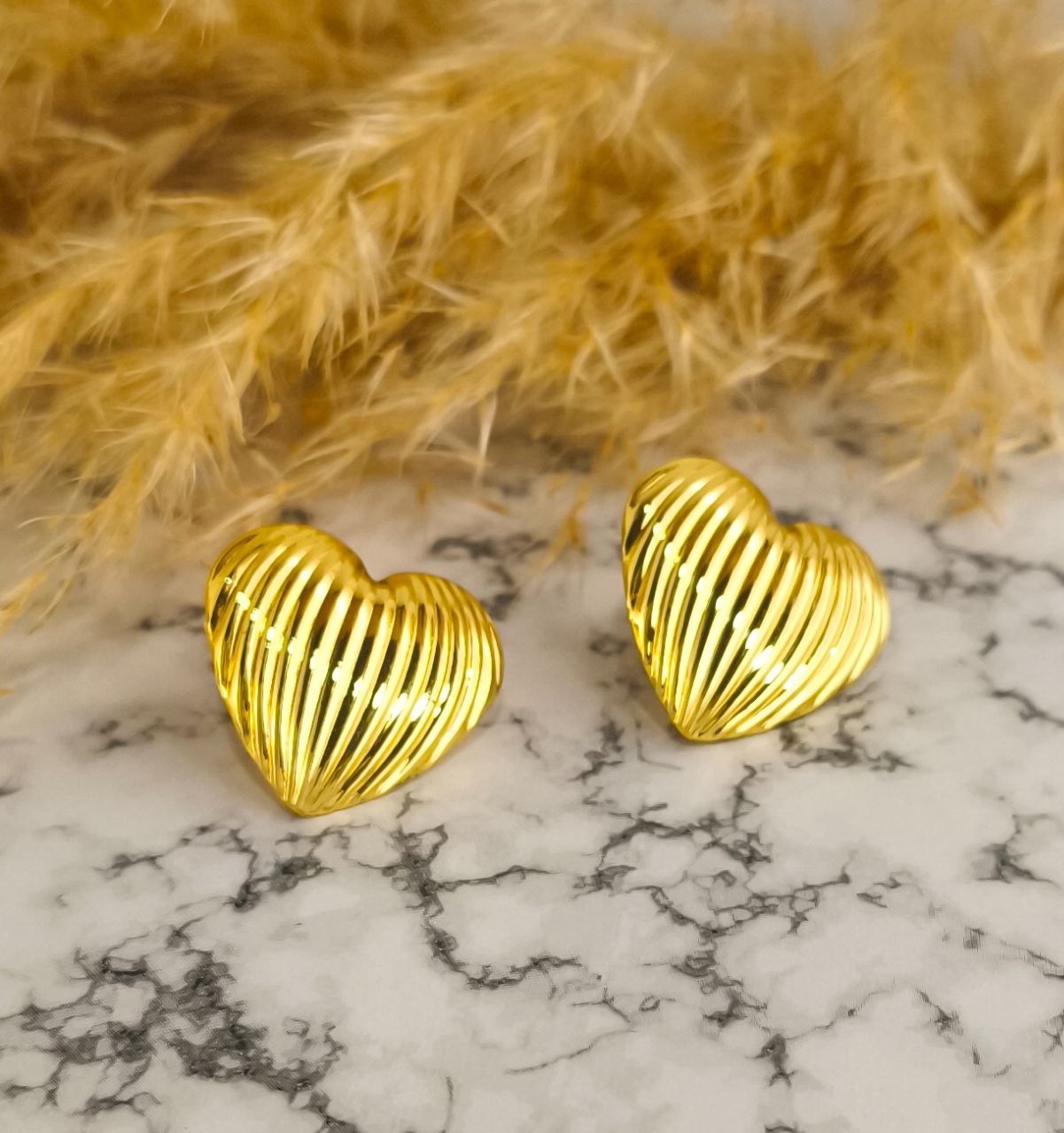 Detalle de aretes corazón en rodio - Calidad hipoalergénica y estuche incluido
