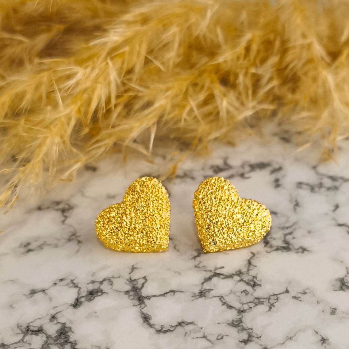 Detalle de textura en aretes corazón martillados - Joyería hipoalergénica premium