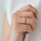 Anillo de compromiso con esmeralda colombiana y diamantes puesto en mano de mujer, joyería artesanal Colombia