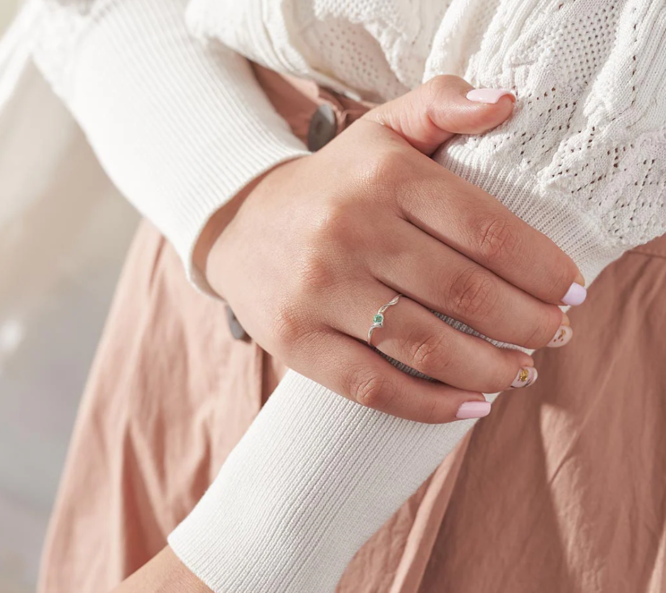 Anillo de compromiso con piedra natural esmeralda puesto en mano de mujer, hecho a mano Colombia