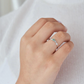 Anillo de compromiso orgánico con esmeralda colombiana y diamantes de laboratorio puesto en mano de mujer, joyería artesanal Colombia