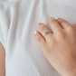 Anillo de compromiso elegante con esmeralda colombiana y diamantes blancos de laboratorio puesto en mano de mujer, joyería hecha a mano Colombia