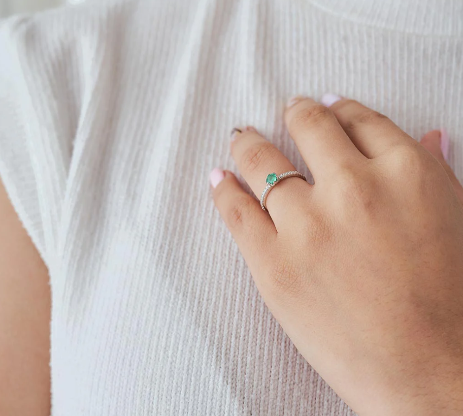 Anillo de compromiso elegante con esmeralda colombiana y diamantes blancos de laboratorio puesto en mano de mujer, joyería hecha a mano Colombia