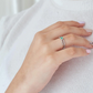 Anillo de compromiso elegante con esmeralda colombiana y diamantes blancos diseño nudos puesto en mano de mujer, hecho a mano Colombia