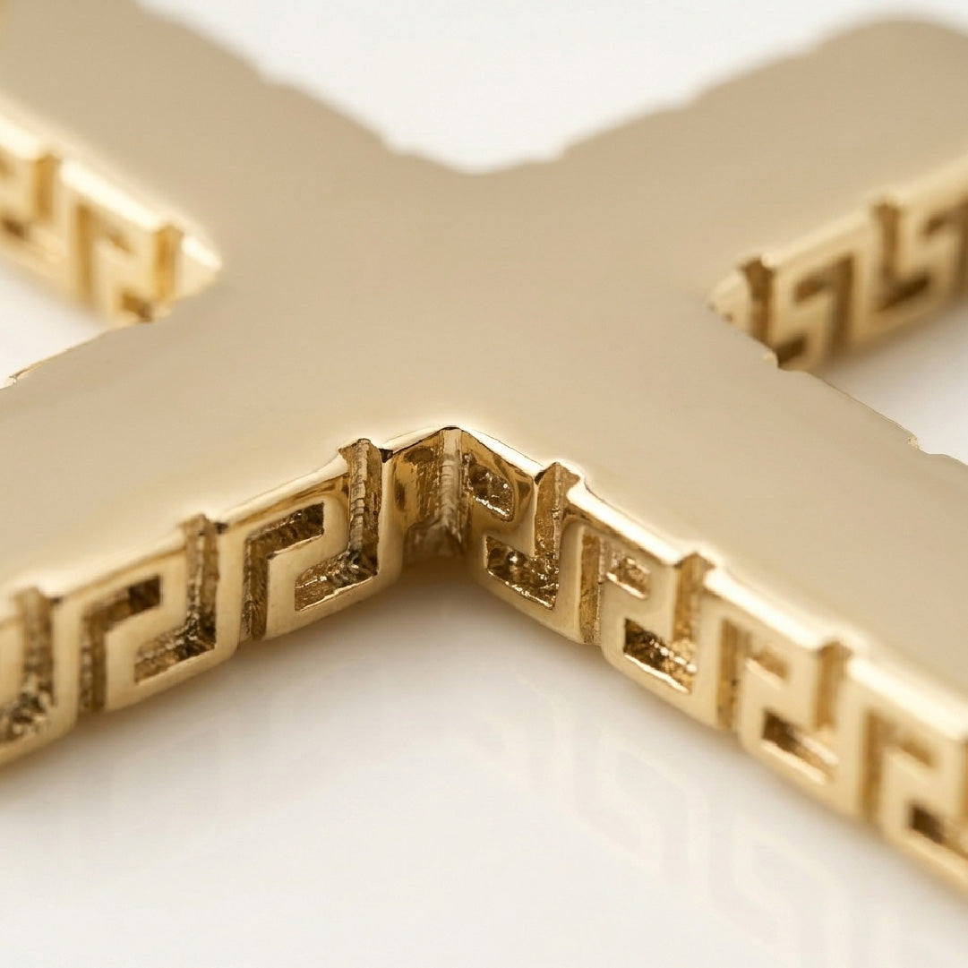 Detalle macro textura greca dije cruz oro laminado 18k - grabado artesanal bordes dorados Brillo Encanto