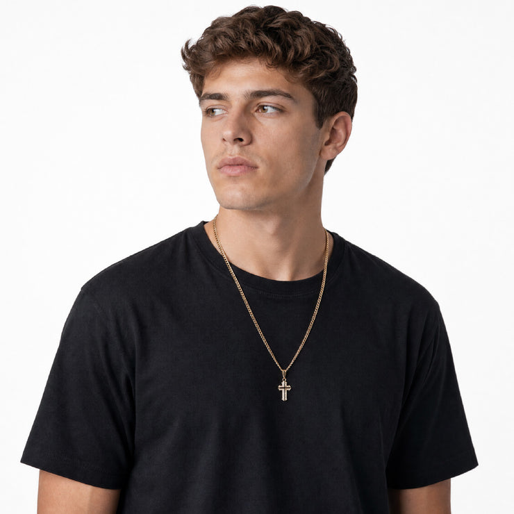 Hombre joven con dije cruz oro 18k sobre cadena dorada y camiseta negra - joyería de lujo Colombia