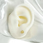 Arete de corona en oro laminado 18K puesto en oreja de silicona