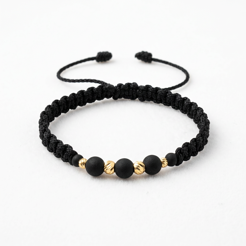 Pulsera unisex de hilo negro tejido con cuentas negras y balines de oro 18K, con cierre ajustable.