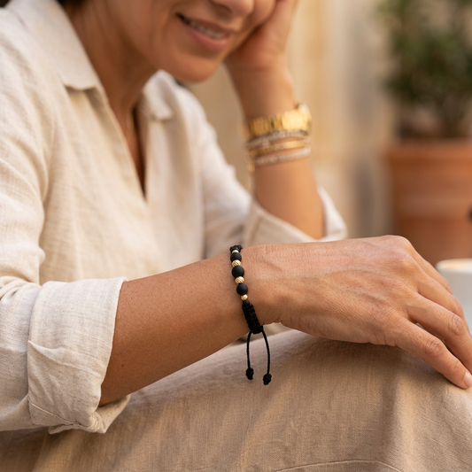 Pulsera unisex de hilo negro tejido con BALINES negros y balines de oro 18K, con cierre ajustable.